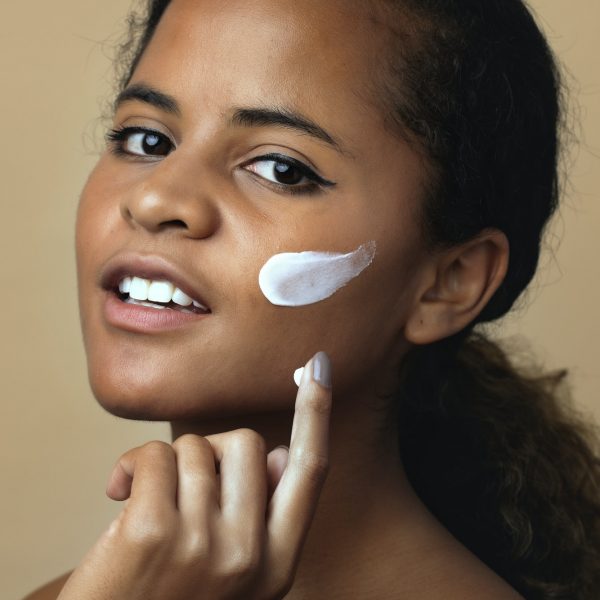 Woman applying moisturizing cream for skincare